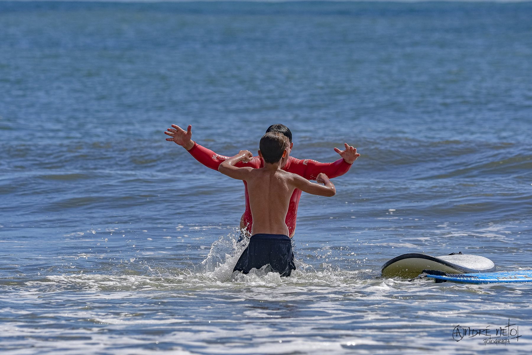 Pai e filho se encontrando no mar, comemorando depois da onda
